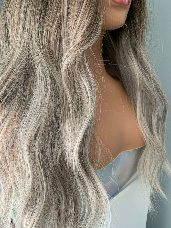 Close-up of long wavy grey silver wig showcasing beachy waves and natural movement for a stylish look.