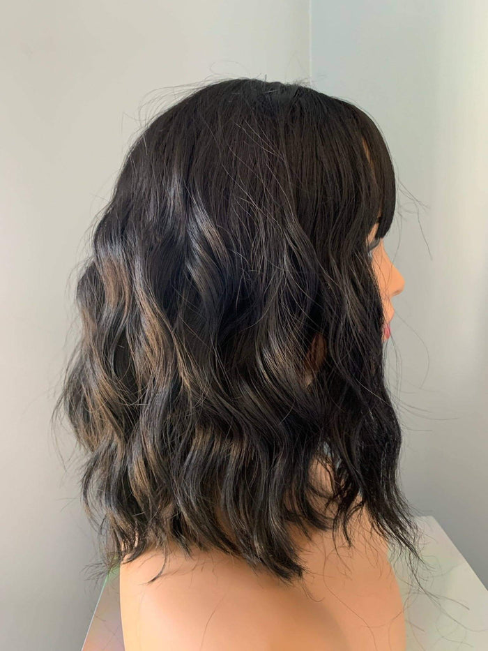 Person with shoulder-length wavy hair against a neutral background