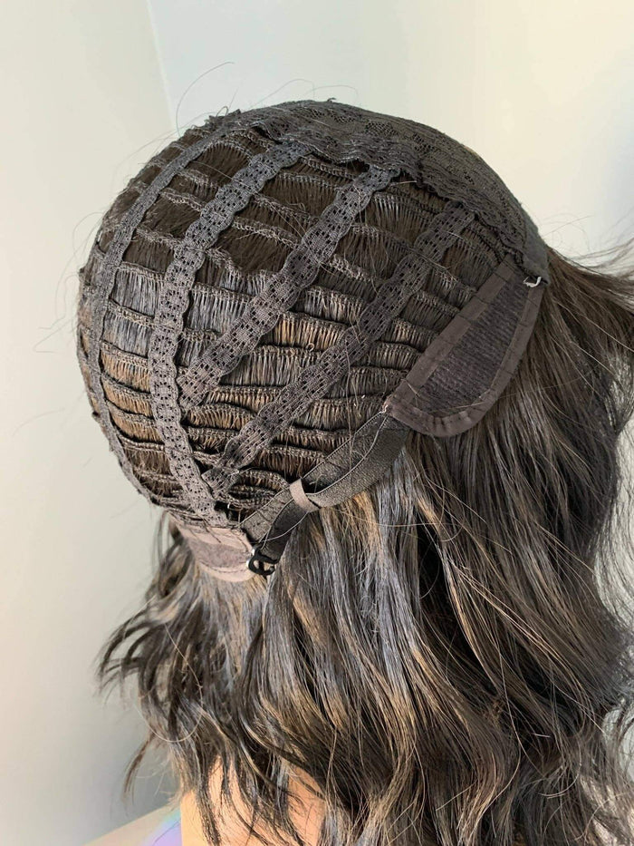 Close-up of a wig with a lace front on a mannequin head against a white background